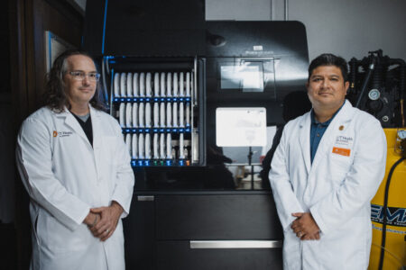 Richard Zimmermann, DDS, BS, clinical associate professor of comprehensive dentistry at UT Health San Antonio, left, and Luis Enrique Reyes, lab supervisor, flank the Matik, a highly automated machine for milling dental prosthetics.