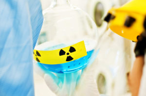 Radiation Research And Development: Scientist Examines Blue Radioactive Liquid Substance in Beaker